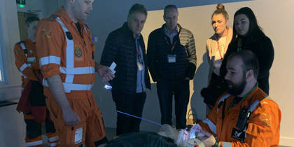 Two paramedics giving demonstrations to visitors inside the charity's iSim training facility.
