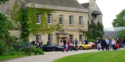 A photo of Middlewick House with sports cars parked outside and visitors taking photos and looking at the cars. A photo of Middlewick House with sports cars parked outside and visitors taking photos and looking at the cars.