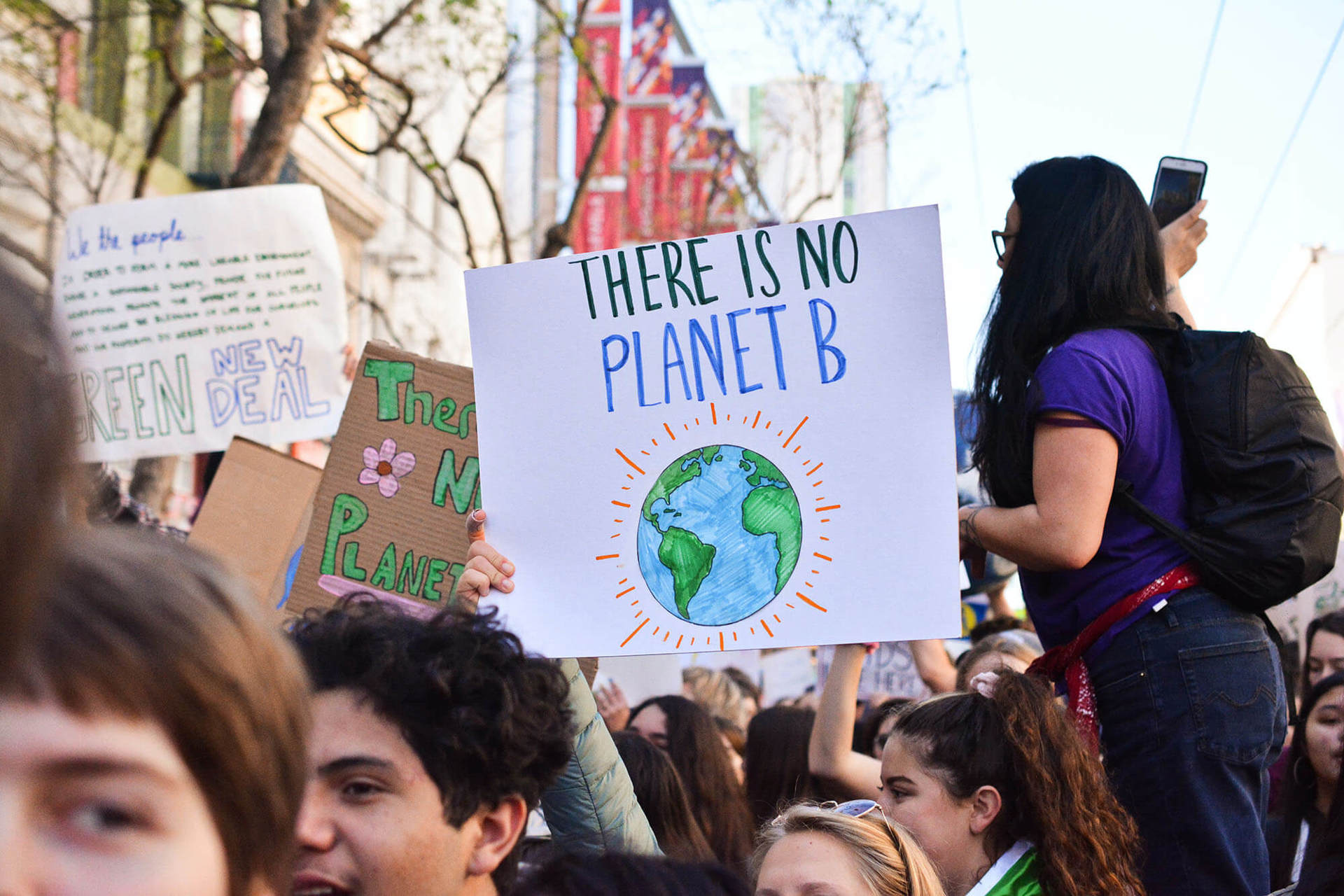 A person holding a sign with an illustration of the earth with the words 'There is no planet B' A person holding a sign with an illustration of the earth with the words 'There is no planet B'