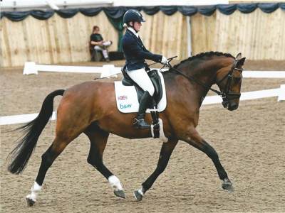 Suzanna Hext riding a horse at a show event