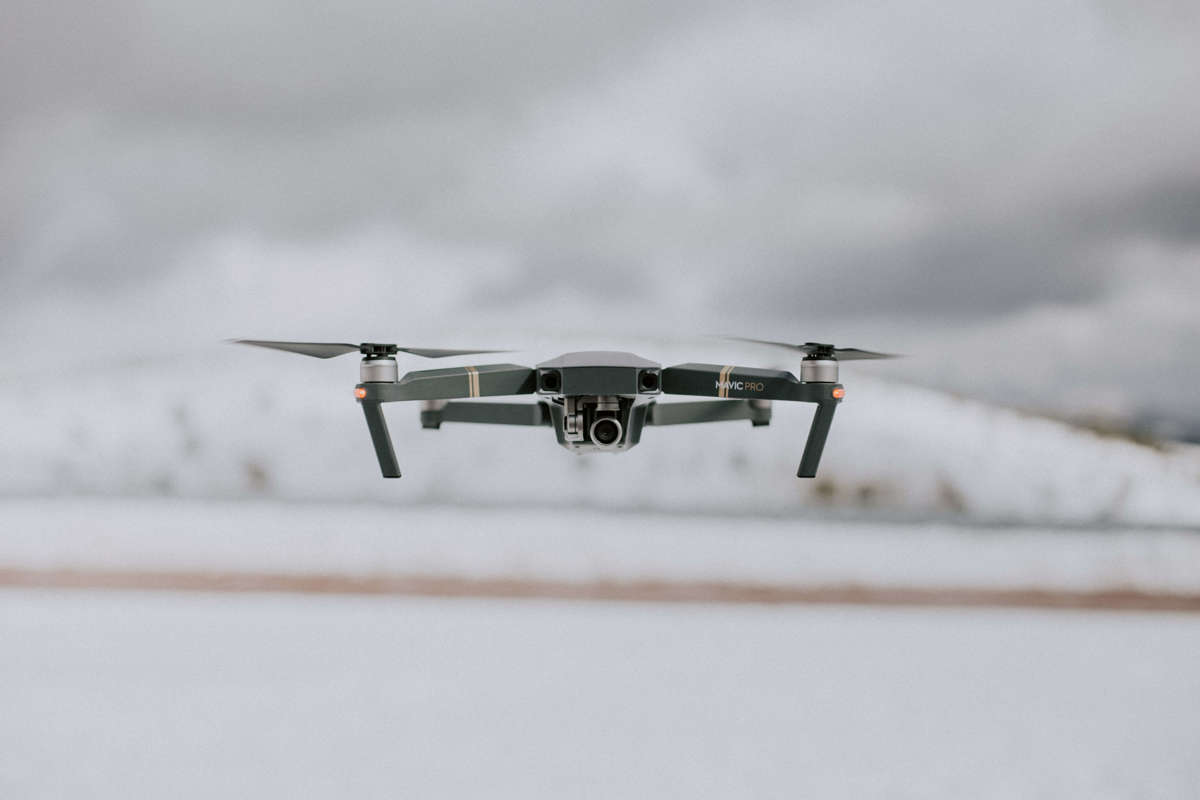 A photograph of a drone in flight on a white background.