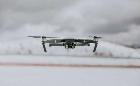 A photograph of a drone in flight on a white background. A photograph of a drone in flight on a white background.