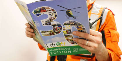 A critical care paramedic wearing an orange flight suit and reading the 30 years anniversary edition of Lift Off magazine. A critical care paramedic wearing an orange flight suit and reading the 30 years anniversary edition of Lift Off magazine.