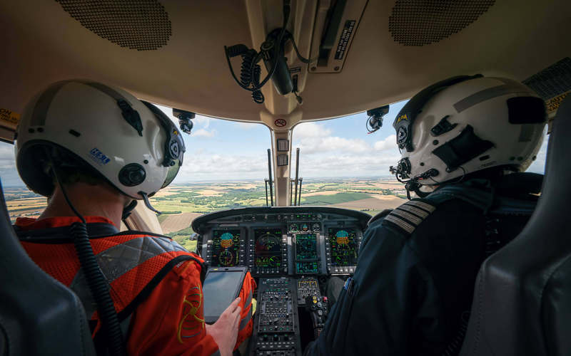 A paramedic and pilot sat in the cockpit of the helicopter whilst in flight. A paramedic and pilot sat in the cockpit of the helicopter whilst in flight.