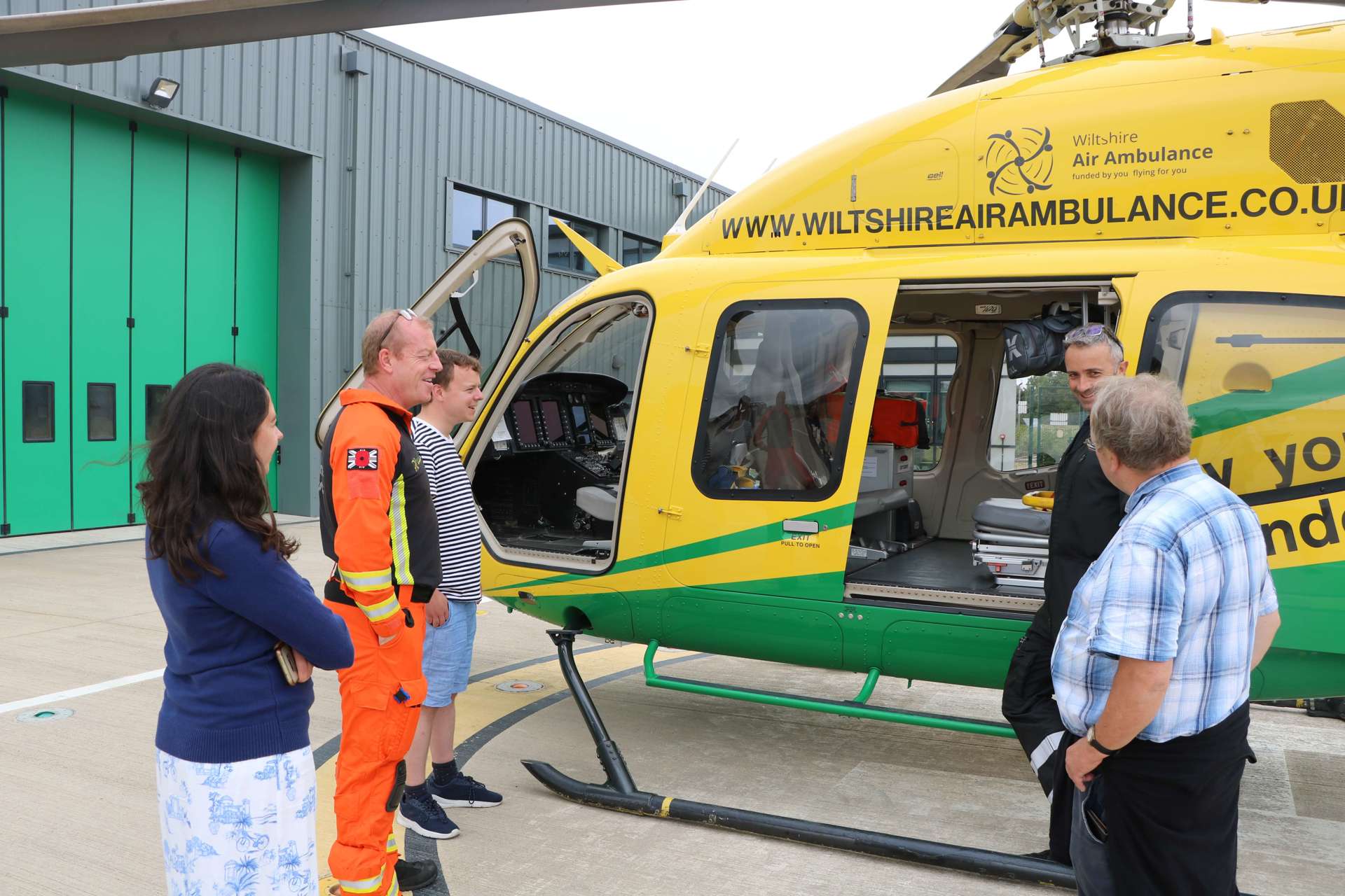 A former patient speaking to a pilot and paramedic next to the Bell-429 helicopter A former patient speaking to a pilot and paramedic next to the Bell-429 helicopter