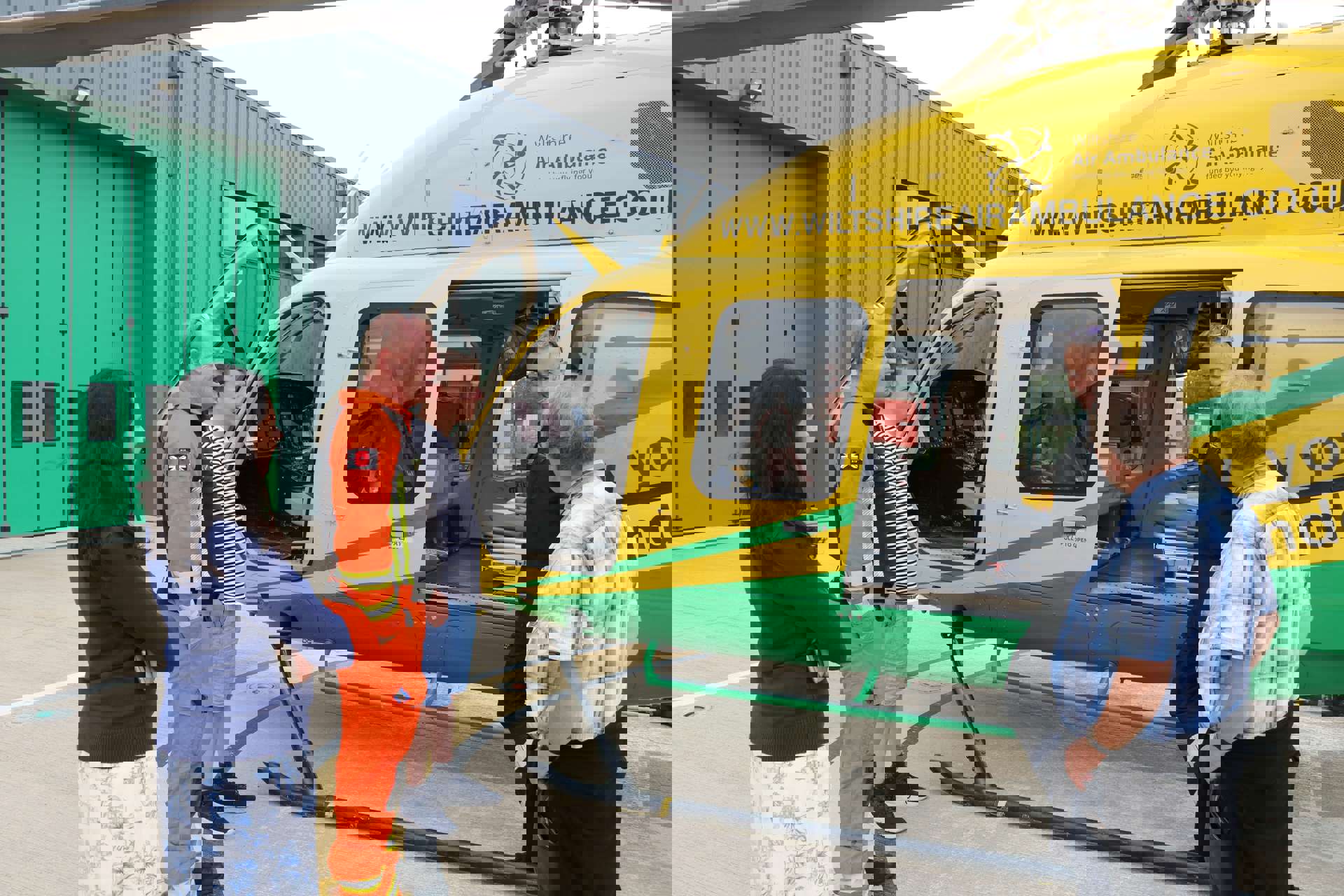 A former patient speaking to a pilot and paramedic next to the Bell-429 helicopter A former patient speaking to a pilot and paramedic next to the Bell-429 helicopter