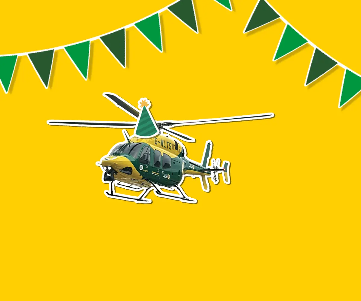 A yellow background with a sticker of the yellow and grey Bell 429 helicopter wearing a cartoon sticker hat, with green bunting around it A yellow background with a sticker of the yellow and grey Bell 429 helicopter wearing a cartoon sticker hat, with green bunting around it