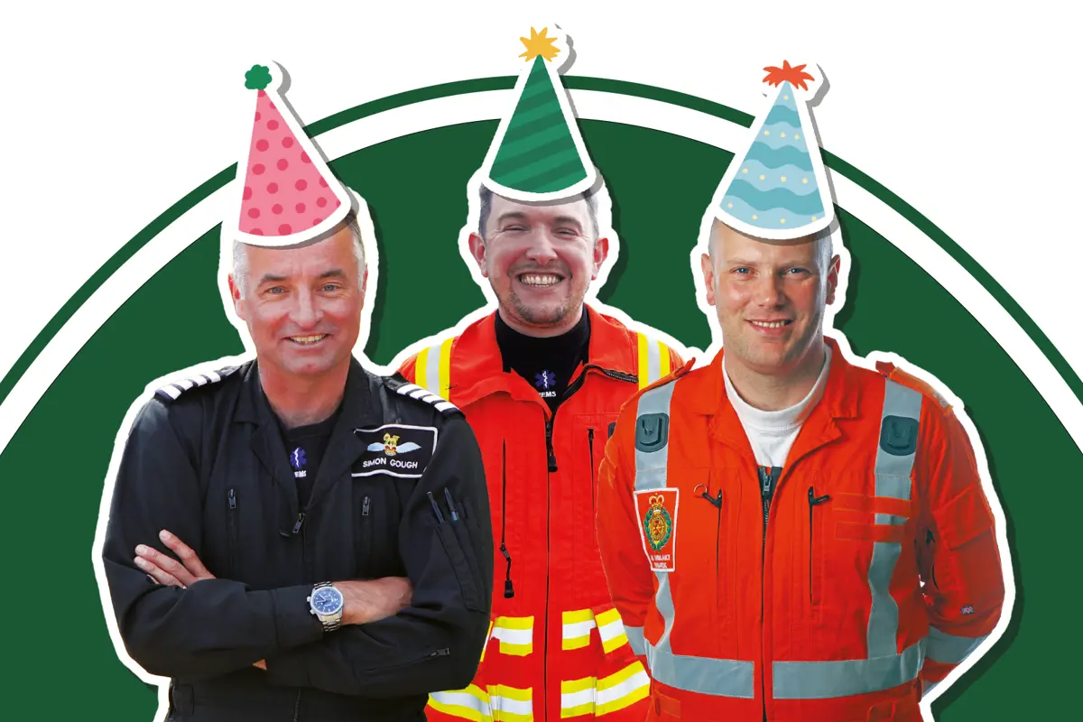 A pilot, doctor and paramedic wearing flight suits with cartoon style party hat stickers on