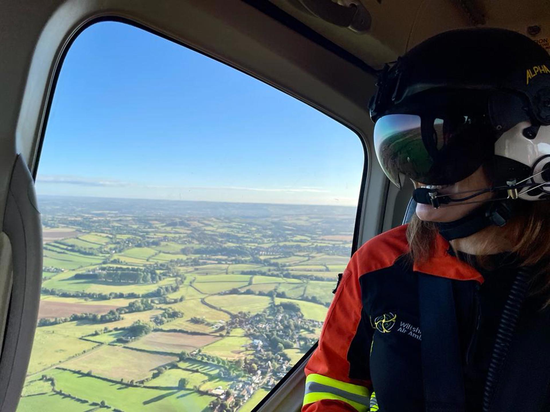 Dr Rosie Furse in the Wiltshire Air Ambulance helicopter admiring the view from above of green fields and sunny skies. Dr Rosie Furse in the Wiltshire Air Ambulance helicopter admiring the view from above of green fields and sunny skies.