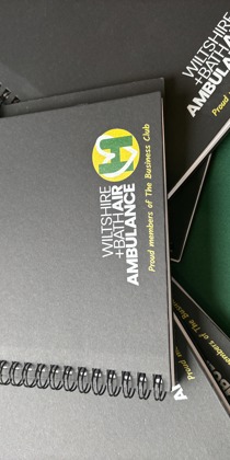 Black notebook and pen with yellow and green Wiltshire and Bath Air Ambulance logo Black notebook and pen with yellow and green Wiltshire and Bath Air Ambulance logo