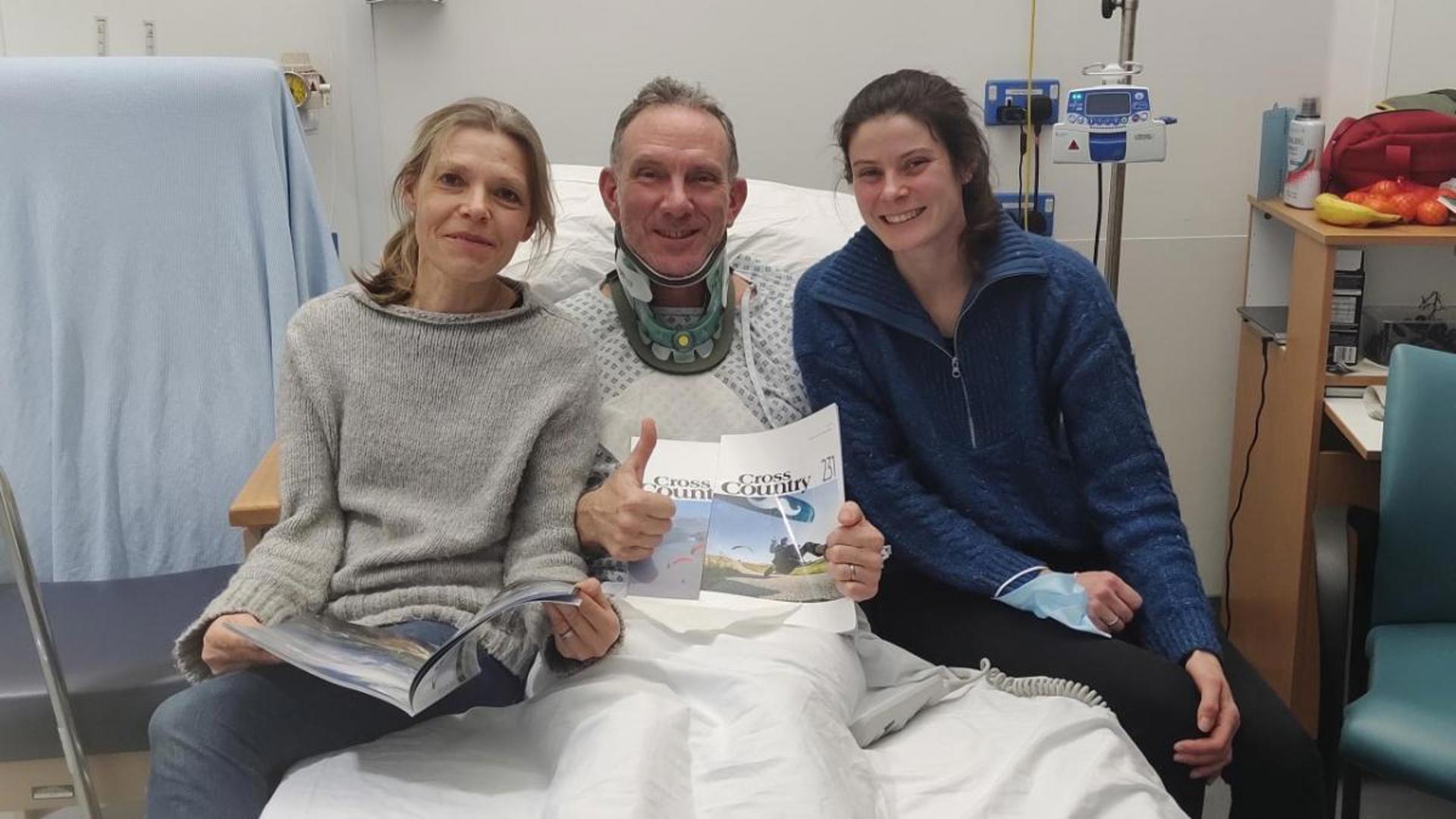 Three people sat on a hospital bed Three people sat on a hospital bed