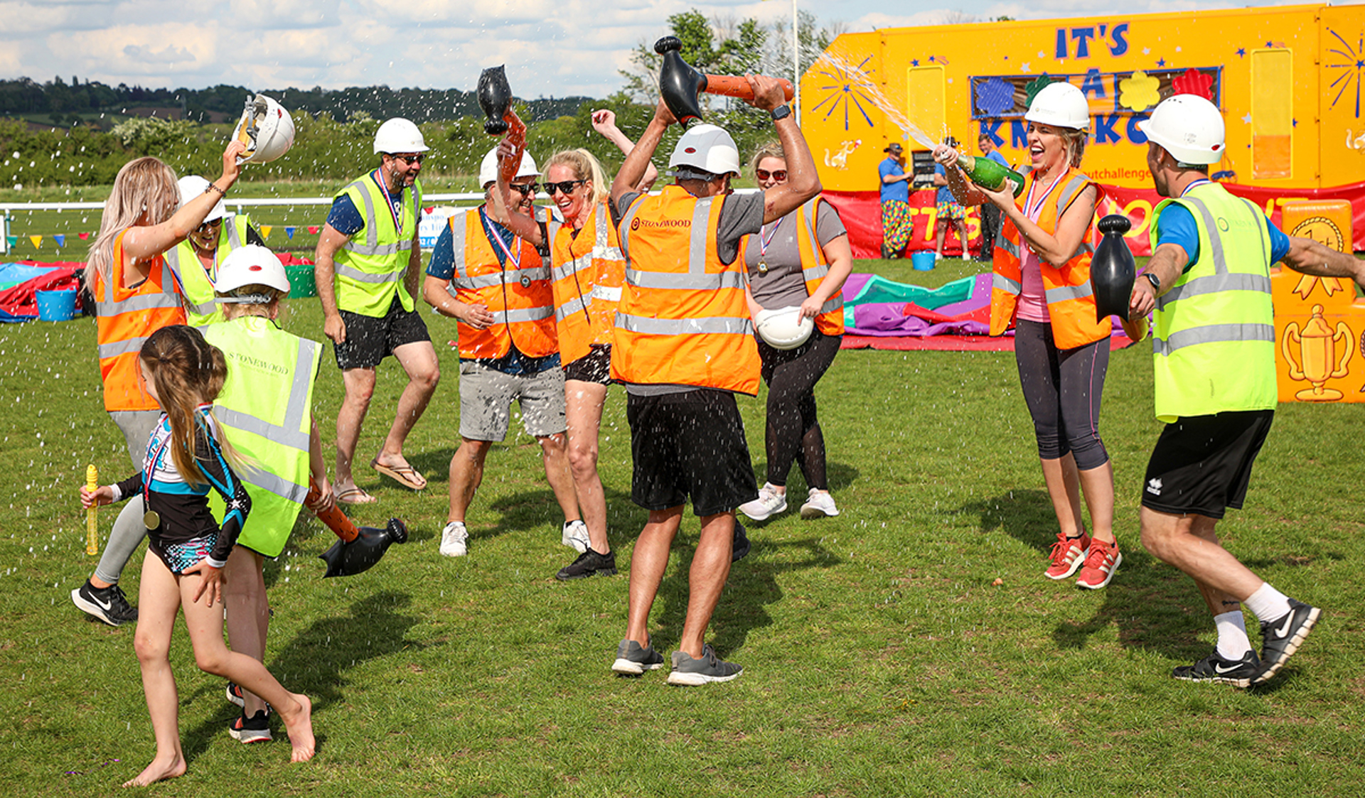 A group of supporters celebrating their win at It's a Knockout event with champagne A group of supporters celebrating their win at It's a Knockout event with champagne