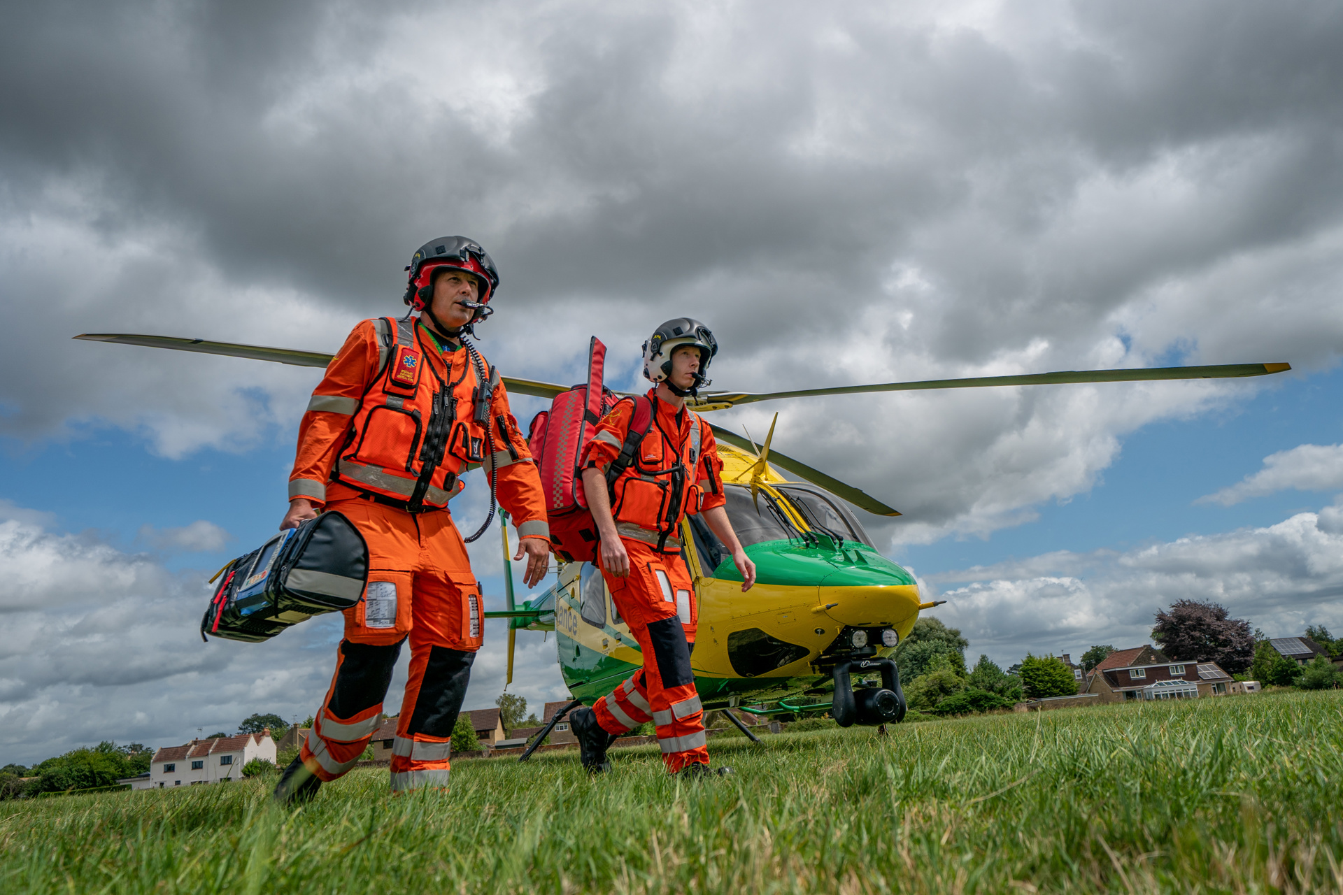 Two paramedics walking away from the helicopter towards a staged incident in a field Two paramedics walking away from the helicopter towards a staged incident in a field