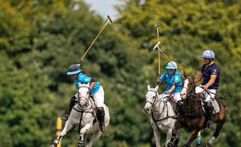 A group of three people playing polo at Stonehenge Polo Festival