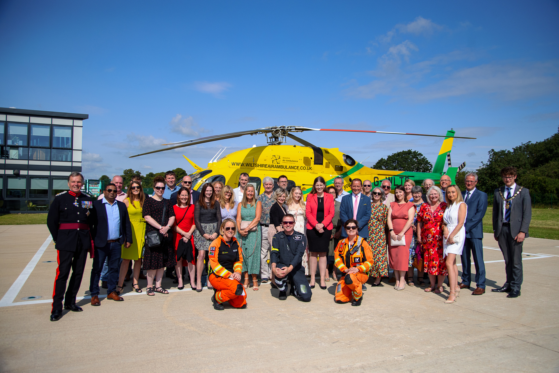 A photo of the Coombe Castle team by the wiltshire air ambulance aircraft on a sunny day A photo of the Coombe Castle team by the wiltshire air ambulance aircraft on a sunny day