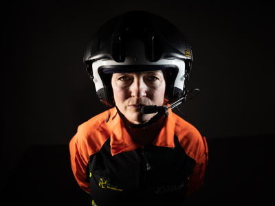 Critical care paramedic Jo Gilbert wearing a flight suit and helmet looking on a black background. Critical care paramedic Jo Gilbert wearing a flight suit and helmet looking on a black background.