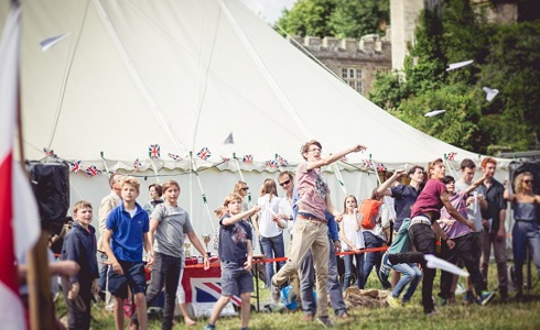 A group of people taking part in traditional games in front of a gazebo at a Teffont Village fete