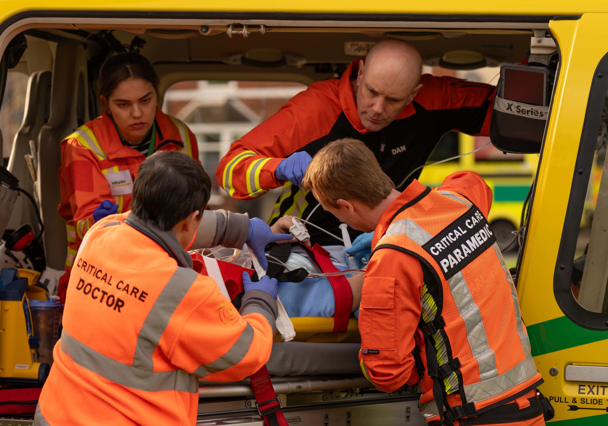 A team of critical care paramedics and doctors working on a patient on a stretcher in the back of the charity's helicopter A team of critical care paramedics and doctors working on a patient on a stretcher in the back of the charity's helicopter
