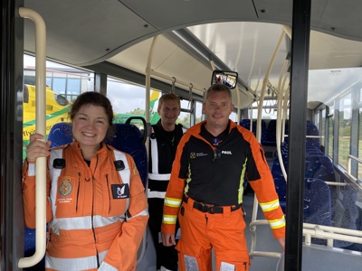 Paramedics Jo and Rocky, and Pilot Fin standing on a bus with the Wiltshire Air Ambulance helicopter in the background Paramedics Jo and Rocky, and Pilot Fin standing on a bus with the Wiltshire Air Ambulance helicopter in the background