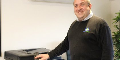 A man posing with a printer A man posing with a printer